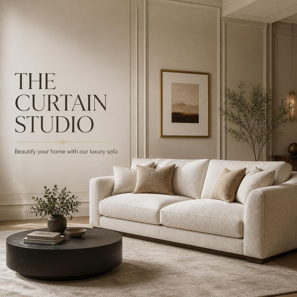 Modern cream fabric luxury sofa with throw pillows and round wooden coffee table in an elegant living room setup by The Curtain Studio