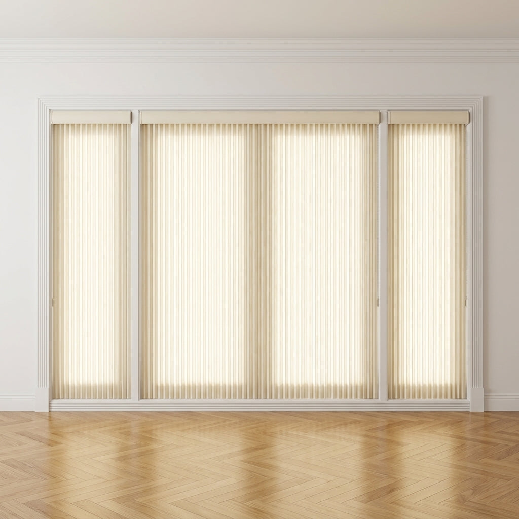 A set of beige vertical blind roller shades installed on a large window or sliding glass door in a bright room with light walls and a herringbone wood floor.