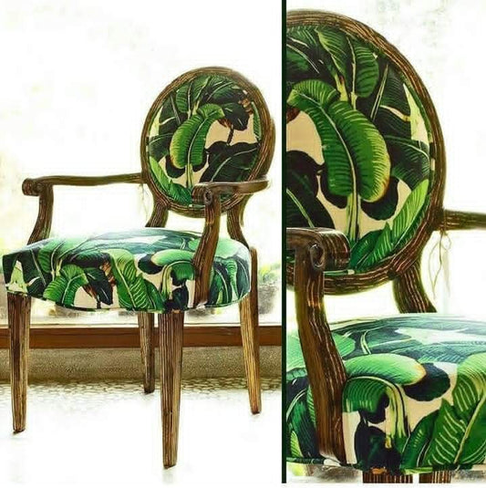 An upholstered wooden dining chair shown in a split view: a full side view on the left and a close-up of the backrest and seat on the right. The chair has a dark brown wood frame and green tropical leaf print upholstery on a light cream background.